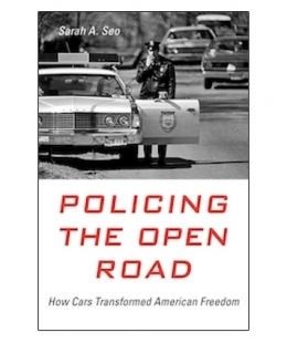 Professor Sarah Seo's book "Policing the Open Road: How Cars Transformed American Freedom" featuring a black and white image of a police officer outside a squad car and speaking on a walkie talkie.