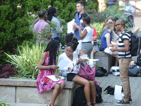 Students sit on Revson Plaza during Orientation