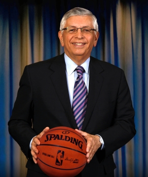 David Stern smiles and poses holding a basketball