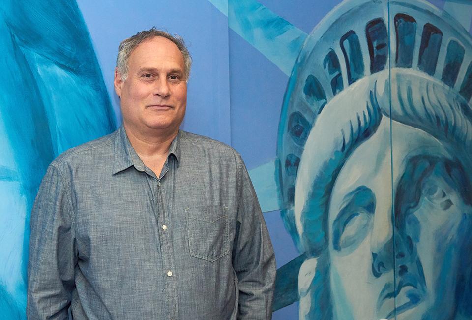 Lee Gelernt ’88 poses by a mural of the Statue of Liberty.