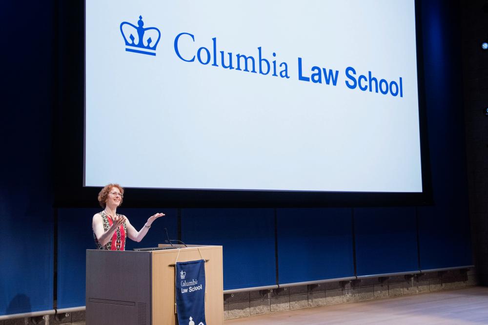 Dean Gillian Lester stands in front of a screen that says "Columbia Law School."