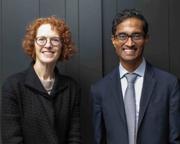 Woman and man in professional attire side by side smiling 