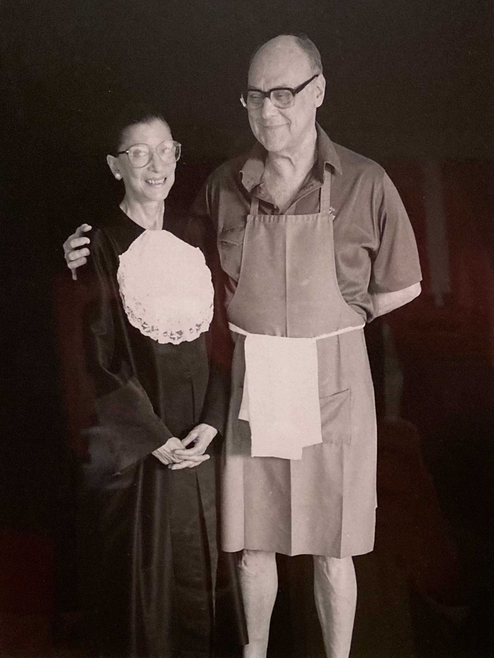 Ruth Ginsburg in a judicial robe and jabot with Marty Ginsburg in an apron