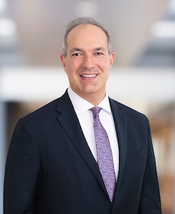 Man in dark jacket, tie and white shirt