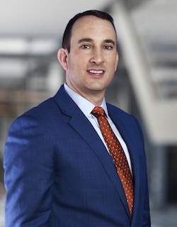 Man in blue jacket, white shirt and red tie