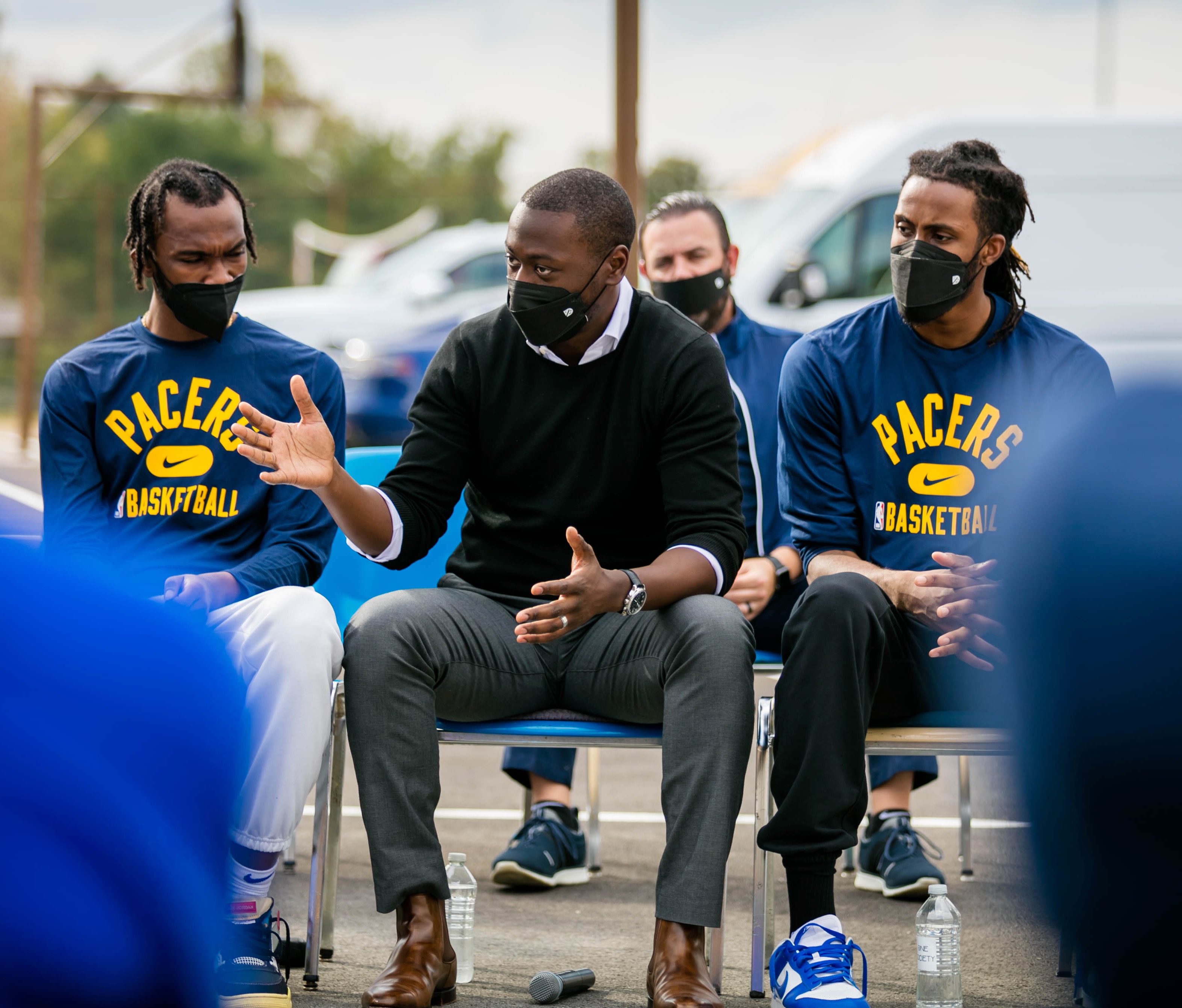 Man in sweaters between two men in Pacers sweatshirts