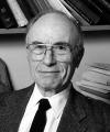 Black and white photo of man in suit wearing glasses