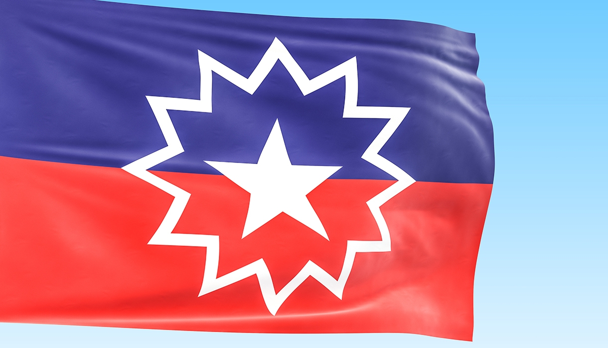 Flag for Juneteenth showing a purple and red stripe and white star inside of a starburst.