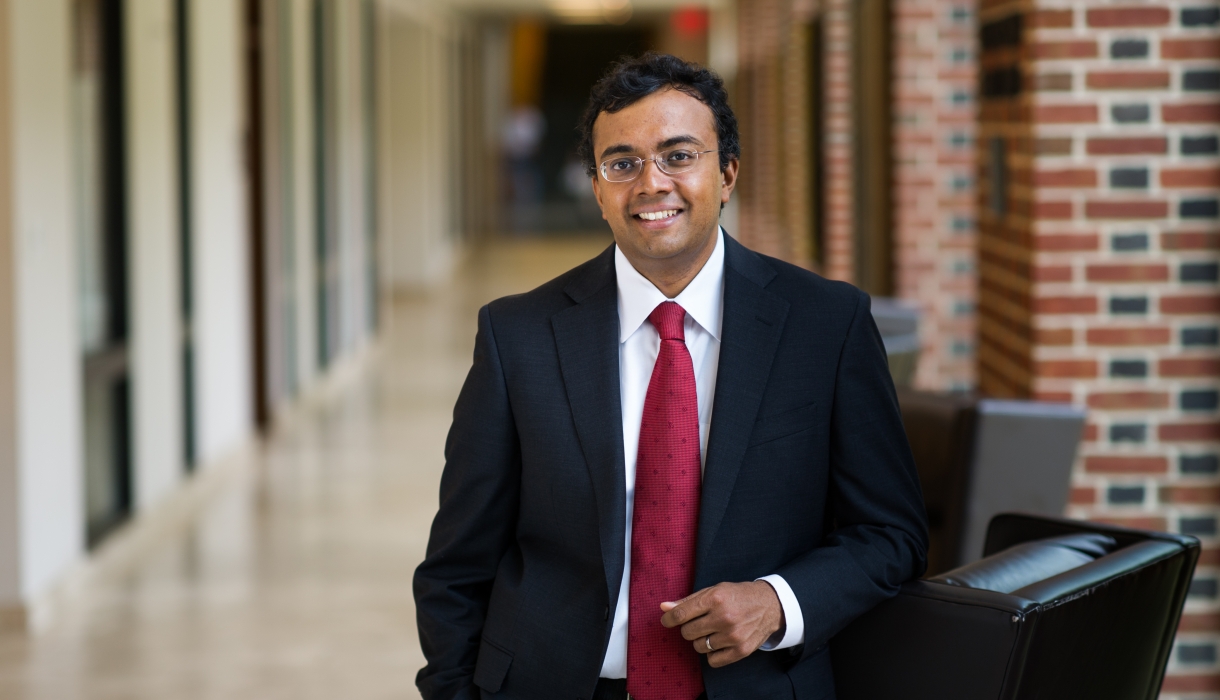 Law professor in black suit and red tie