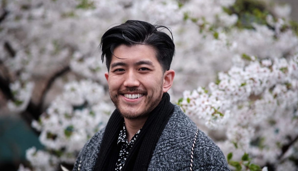 Taoxin (Xin) Wang standing in front of white blossoms