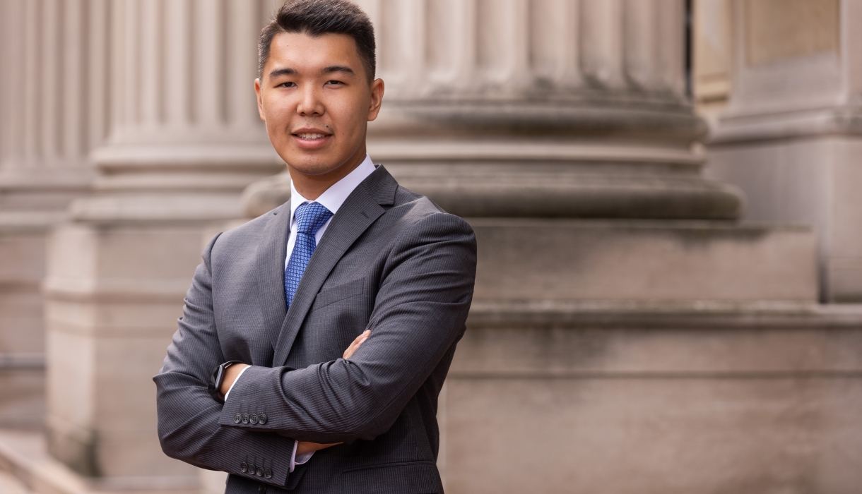 Man with short dark hair in dark great suit and blue tie