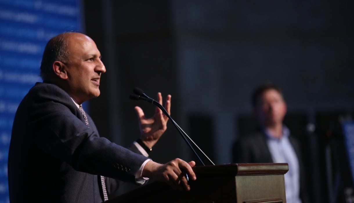 Man speaking and gesturing at podium