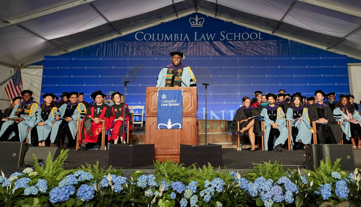 Stage of Columbia Law graduation with hydrangeas and dignitaries