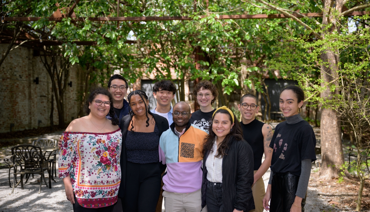 Group of nine law students standing in a shady courtyard