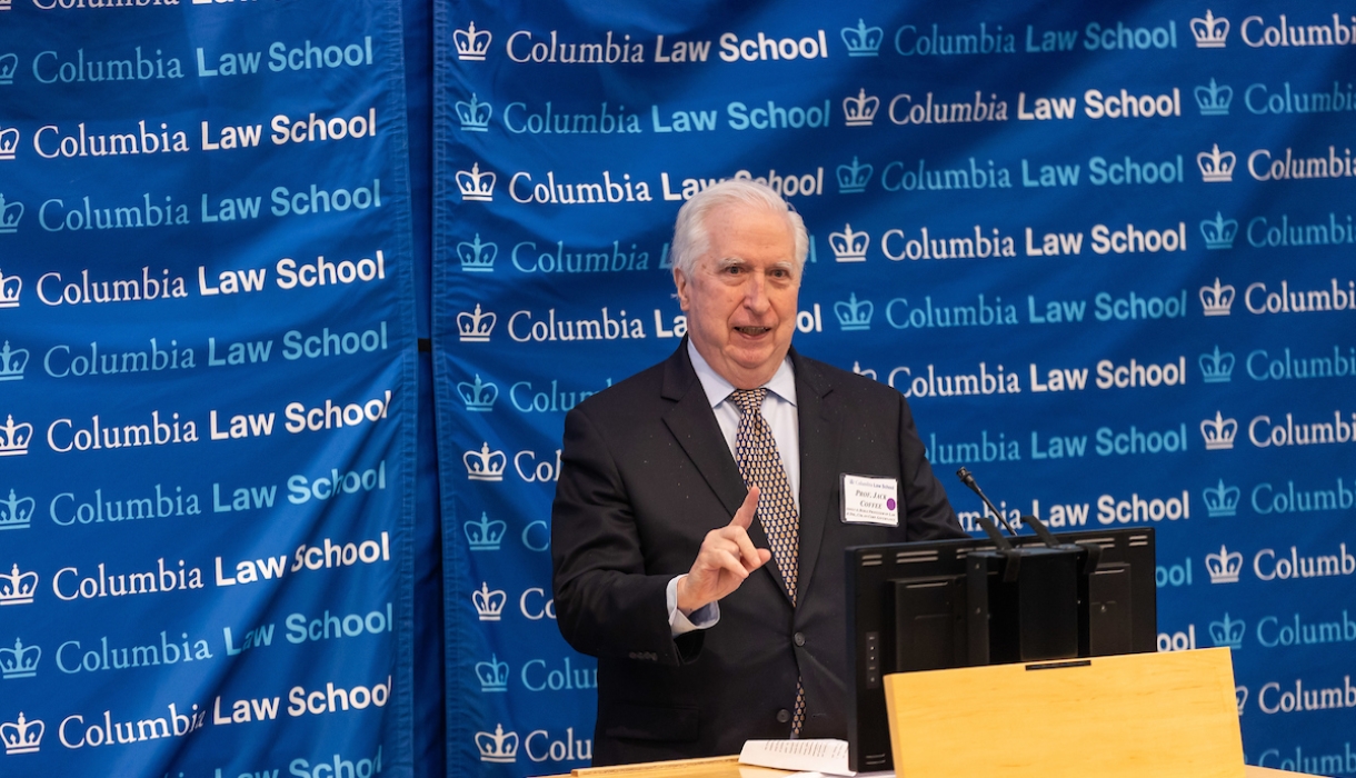 Man in tie at podium in front of Columbia Law School banner