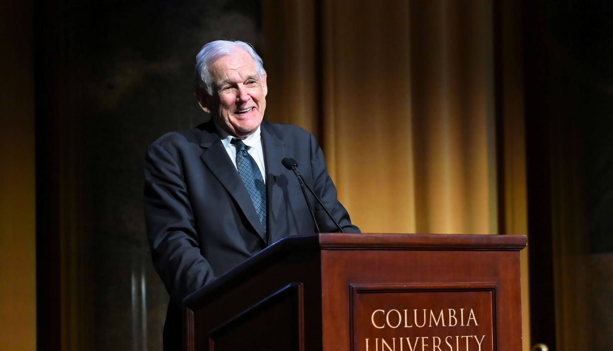 Professor George Bermann in suit and tie speaking in front of a Columbia University podium