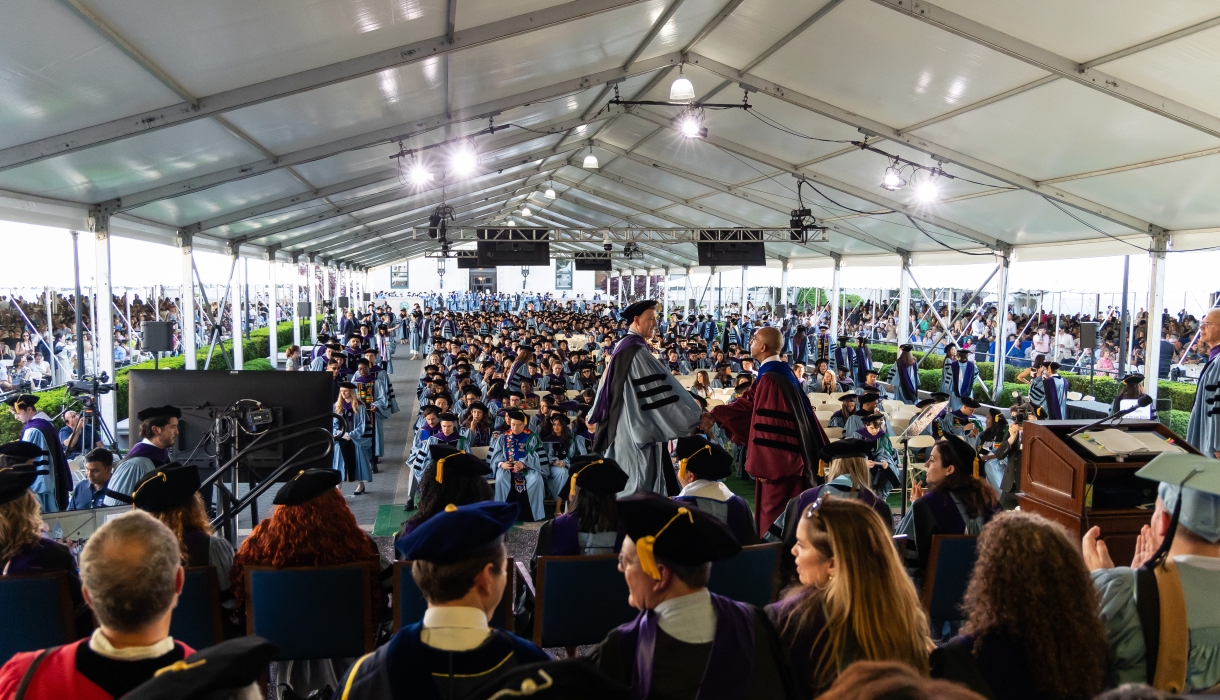 A graduate shakes hands with Dean Abebe at the Class Day ceremony