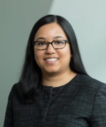 Woman with long dark hair and horn-rim glasses