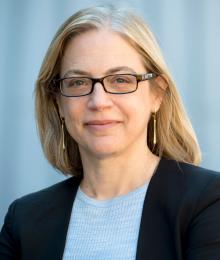 Portrait of Professor Gillian Metzger outside Columbia Law School building, wearing blazer and smiling.