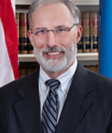 J. Travis Laster