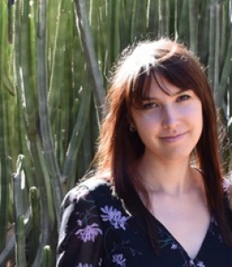 Portrait of Kathleen (Kate) McFarland ’21 LL.M. standing in front of cacti