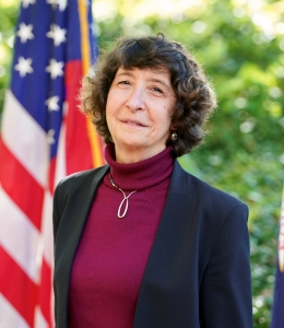 Jocelyn Samuels stands in front of an American flag