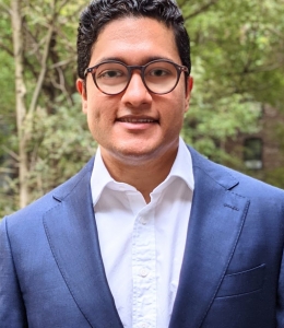 Josh Jacob smiling and wearing a blue suit