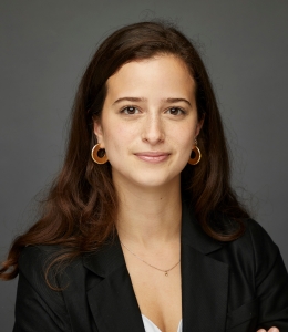 Sarah Al-Shalash smiling and wearing a black suit