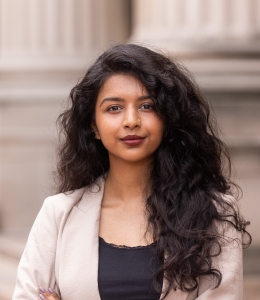 Woman in a beige blazer and black shirt