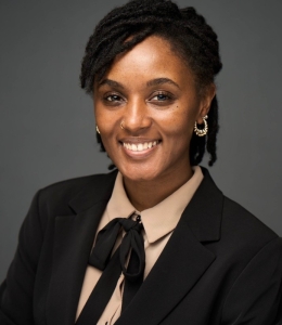 Headshot of a woman wearing a black jacket and beige blouse