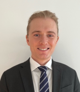 Male student in a suit and blue tie, smiling