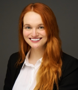 Headshot of a woman wearing a black jacket and white blouse