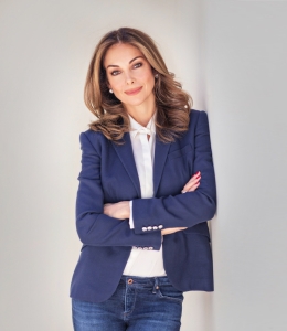 Photo of a woman in a blazer, white shirt, and jeans
