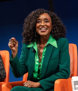Woman speaking seated in a chair onstage 