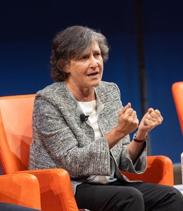 Woman speaking in a chair onstage