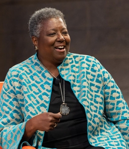 Woman speaking while seated in a chair onstage