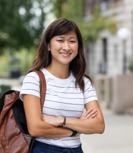 Woman in striped shirt with backpack over shoulder