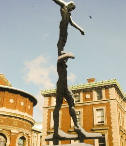 The Tightrope Walker statue, of one human figure balancing on the shoulders of another, is covered in winter snow.