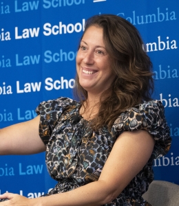Woman on panel smiling and gesturing