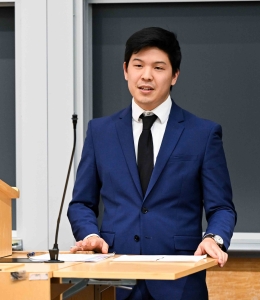 Miles Kim stands behind a podium.