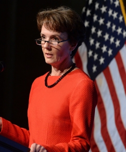 Sarah Cleveland standing at a podium in front of an American flag