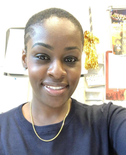 woman with short hair in a dark top smiles