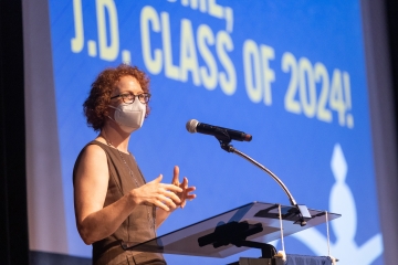 Woman in face mask in front of a microphone