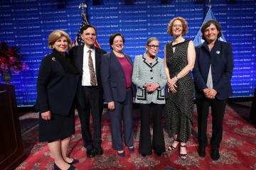 5 women and one man standing on a stage