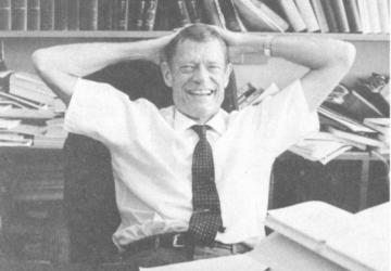 Archival black and white photo of Willis L.M. Reese sitting at a desk in front of a bookshelf.