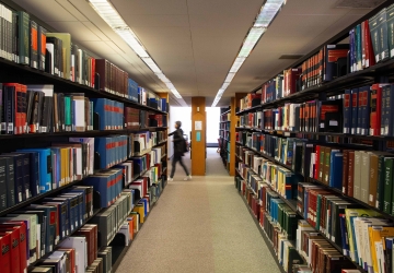 A student walks past a shelf of books in the Diamond Law Library