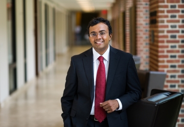 Law professor in black suit and red tie