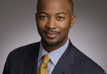 Portrait of man in gray suit with gold tie