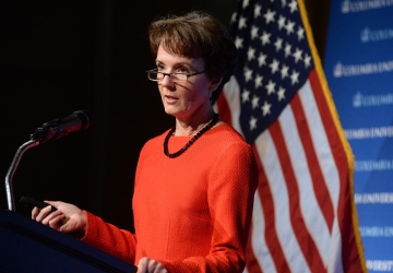 Sarah Cleveland standing at a podium in front of an American flag