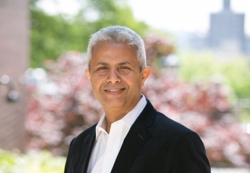 Silver-haired man in white collared shirt and black blazer